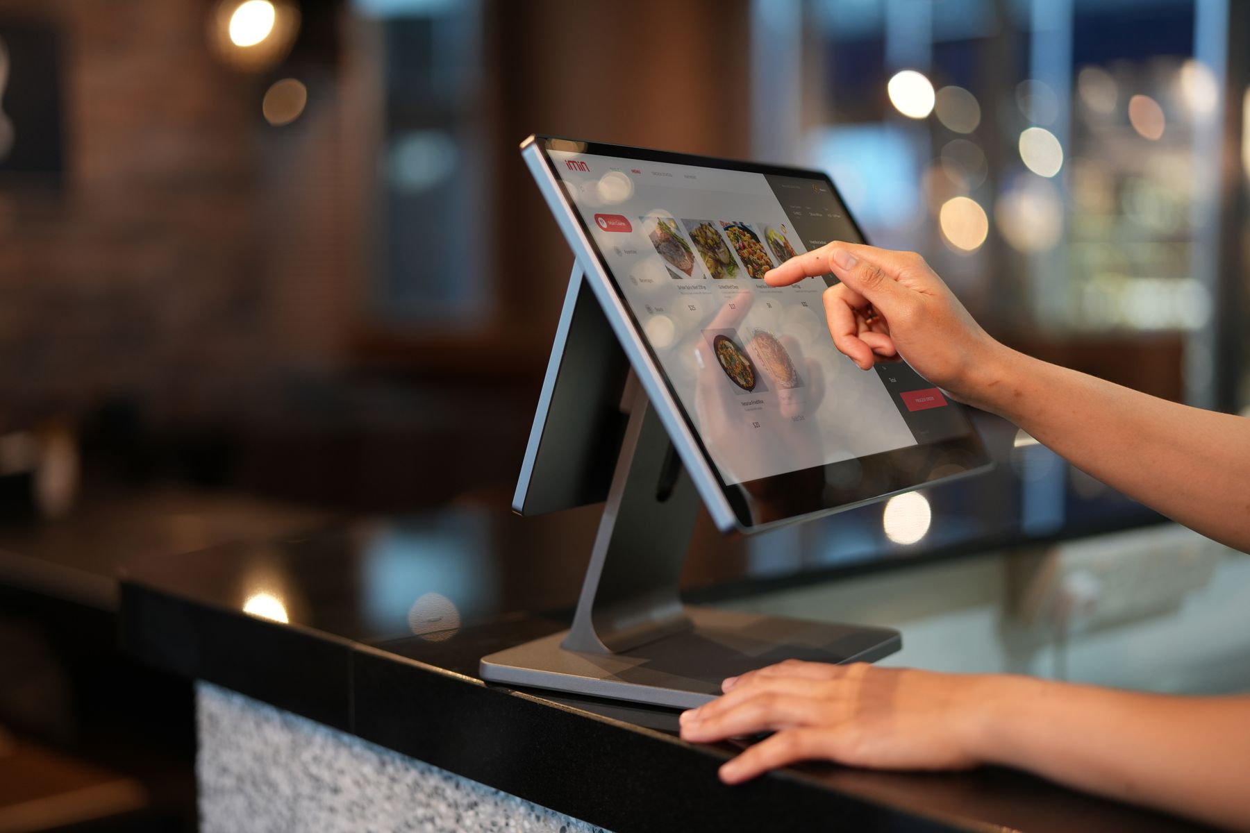 Chef using a digital order display in a professional restaurant kitchen
